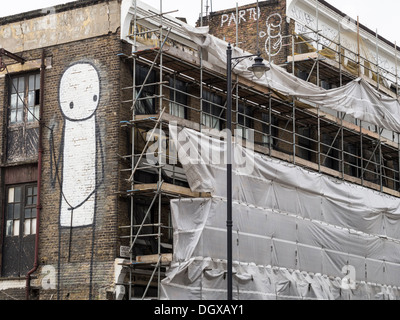 Arte di strada dall'artista Stik sul lato di un edificio rinnovato nella zona est di Londra Foto Stock
