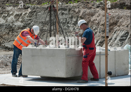 Gli ingegneri strutturali ponendo i primi blocchi durante un edificio sito test di carico in un cantiere in Fridolfing, Bavaria Foto Stock