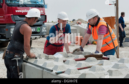 Gli ingegneri strutturali ponendo i primi blocchi durante un edificio sito test di carico in un cantiere in Fridolfing, Bavaria Foto Stock