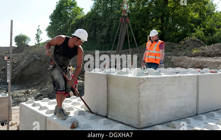 Gli ingegneri strutturali ponendo i primi blocchi durante un edificio sito test di carico in un cantiere in Fridolfing, Bavaria Foto Stock