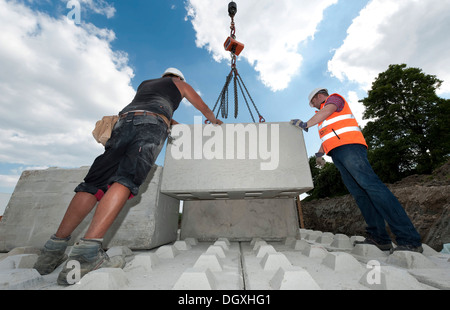 Gli ingegneri strutturali ponendo i primi blocchi durante un edificio sito test di carico in un cantiere in Fridolfing, Bavaria Foto Stock