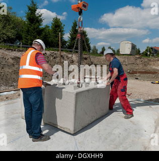 Gli ingegneri strutturali ponendo i primi blocchi durante un edificio sito test di carico in un cantiere in Fridolfing, Bavaria Foto Stock