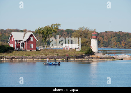 New York, San Lawrence Seaway, migliaia di isole. Pescatore di fronte della piccola isola con il faro. Foto Stock