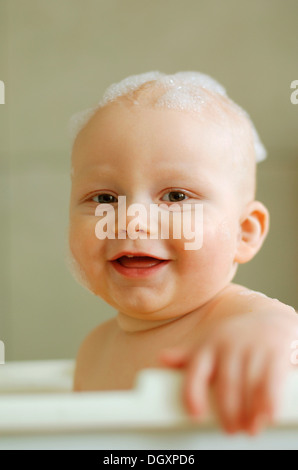 Bambino in un bagno di schiuma sulla sua testa Foto Stock