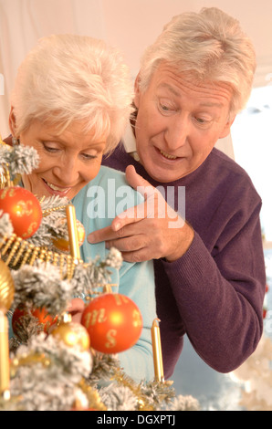 Coppia matura la decorazione di un albero di Natale Foto Stock