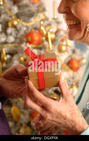 Donna matura ricevere un regalo di Natale Foto Stock