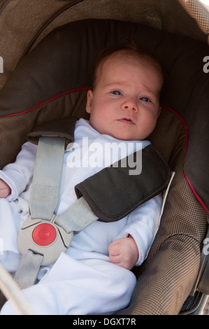 Little Baby girl strapped nel suo passeggino Foto Stock