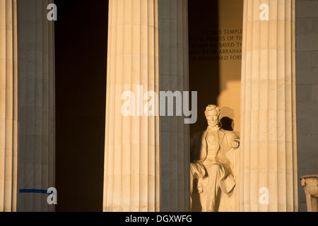 WASHINGTON DC, Stati Uniti: Le colonne e la statua del Lincoln Memorial sono illuminate dalla luce diretta del sole durante un evento stagionale intorno agli equinozi primaverili e autunnali. Il sole nascente splende direttamente nella sala principale, illuminando drammaticamente la statua di Abraham Lincoln. Foto Stock