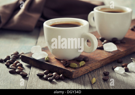 Caffè in tazze con il cardamomo e lo zucchero bianco vintage sfondo di legno Foto Stock