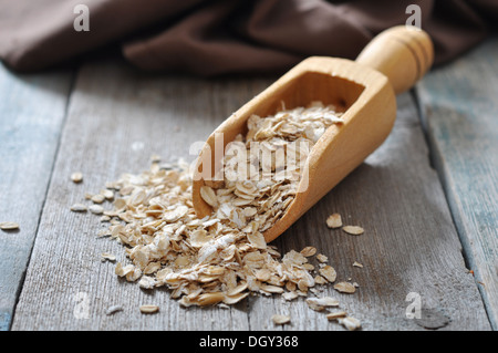 Fiocchi di avena in legno da scoop su sfondo di legno Foto Stock