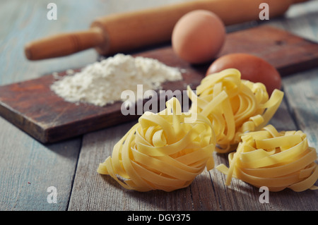 Farina, pasta e mattarello su sfondo di legno Foto Stock