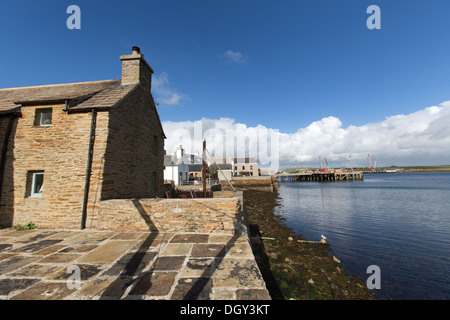 Isole di Orkney, Scozia. Fisherman's Cottage sui Stromness's waterfront, con il porto in background. Foto Stock