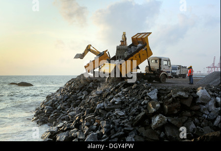 Autocarro con cassone ribaltabile offload di rocce di grandi dimensioni su una parete del mare barriera in Colombo, Sri Lanka Foto Stock