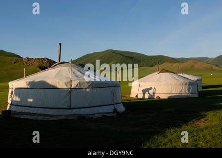 Yurta o ger camp con l'ombra di un uomo lavando, prateria a cascata Orkhon nella parte anteriore delle montagne di Foto Stock