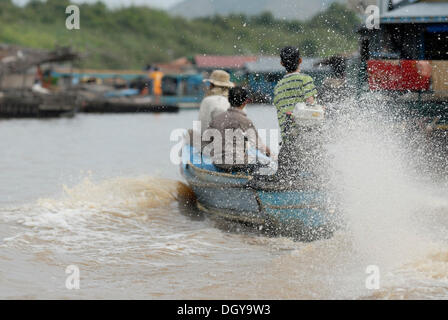 Cambogiano di residenti dei villaggi galleggianti che viaggiano in una longboat motorizzata, Chong Khneas, Lago Tonle Sap, Siem Reap Foto Stock