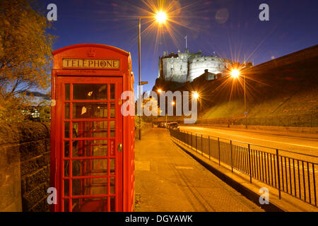 Il Castello di Edimburgo, illuminata di notte, old red britannico phone booth davanti, a Edimburgo, Scozia, Regno Unito Foto Stock