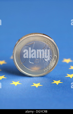 Una moneta Euro sorge su la bandiera dell'UE Foto Stock