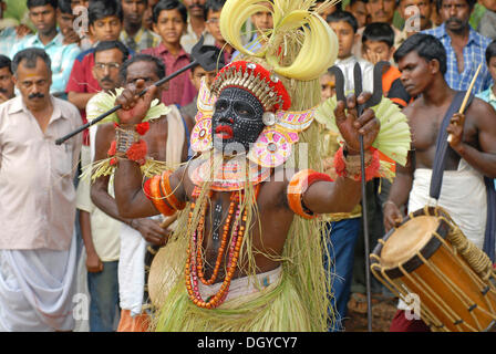 Theyyam esecutore e percussionisti durante un rituale, vicino Kasargod, Nord Kerala, India del Sud, Asia Foto Stock