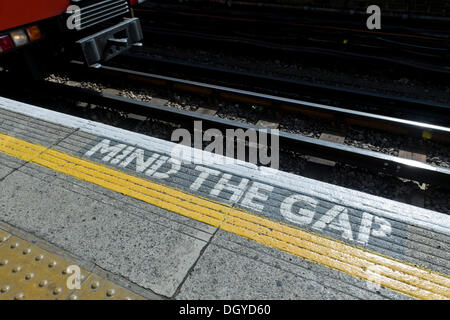 Arrivando in treno e 'Mind gap" segno, Turnham Green tube station, London, England, Regno Unito, Europa Foto Stock