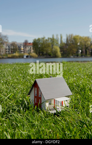 Una casa in miniatura sul prato vicino alla riva di un fiume Foto Stock