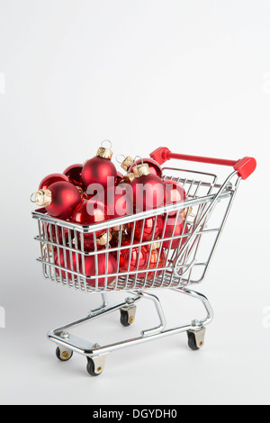 Un carrello pieno di sfera rossa ornamenti per le vacanze Foto Stock