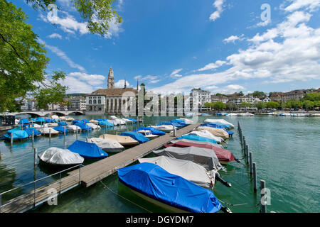 Barche, vista sul fiume Limmat e il Limmatquai alla chiesa Wasserkirche e chiesa Grossmuenster, Zurigo, Svizzera, Europa Foto Stock