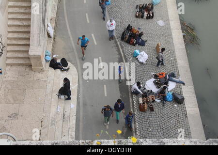 Roma, Italia. 27 ott 2013. Necessità di perseguire da parte della polizia sugli immigrati venditori ambulanti che eludere la cattura da parte del fiume Tevere vicino al Vaticano durante il Pellegrinaggio Internazionale delle Famiglie in piazza San Pietro, Roma Italy © Gari Wyn Williams/Alamy Live News Foto Stock