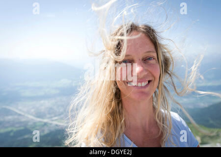 Donna, inizio 40s, con i capelli al vento Foto Stock