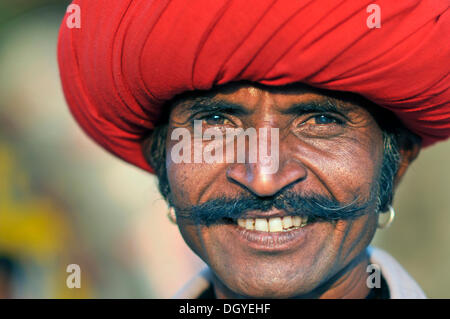 Uomo che indossa un turbante rosso con un baffi e una maglietta blu, sorridente, ritratto, Mandu, Madhya Pradesh, India, Asia Foto Stock