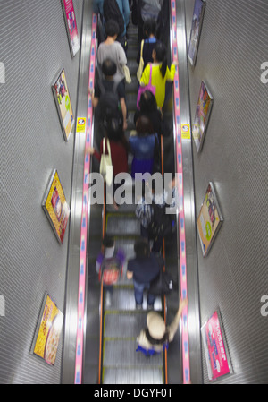 Persone su escalator in Mong Kok alla stazione MTR, Kowloon, Hong Kong, Cina Foto Stock