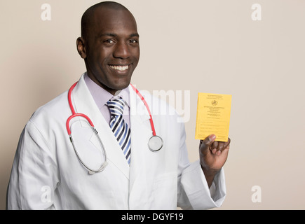 Medico indossa uno stetoscopio azienda tedesca Certificato di immunizzazione Foto Stock