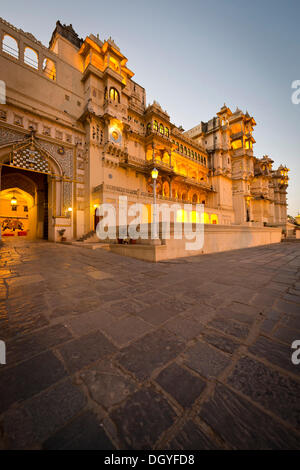 Il cortile e la città illuminata Palazzo del Maharana di Udaipur, Udaipur, Rajasthan, India Foto Stock