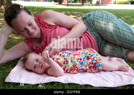 Madre coccolando la sua bambina fuori nel giardino Foto Stock