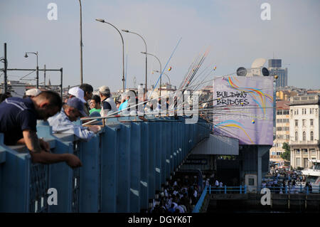 Molti pescatori in piedi in una riga, il ponte Galata, quartiere storico di Istanbul, Turchia, europa Foto Stock