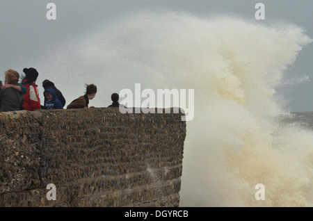 La gente sulla parete del mare con onde che si infrangono durante la tempesta, Brighton, Inghilterra Foto Stock