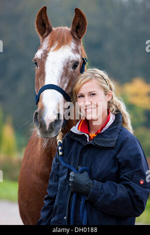 Giovane donna con un austriaco Warmblood, castagna cavallo Foto Stock