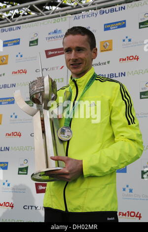 Dublino, Irlanda. 28 ott 2013. Runner irlandese Sean Hehir ha vinto gli uomini di gara del 2013 Airtricity maratona di Dublino in 2:18:19. Egli è il primo corridore irlandese a vincere la maratona in vent'anni. Il vincitore di uomini della gara, Sean Hehir (M) illustra il Noel Carroll Memorial Trophy. Egli è il primo uomo irlandese per vincere. Credito: Michael Debets/Alamy Live News Foto Stock