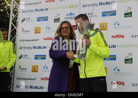 Dublino, Irlanda. 28 ott 2013. Runner irlandese Sean Hehir ha vinto gli uomini di gara del 2013 Airtricity maratona di Dublino in 2:18:19. Egli è il primo corridore irlandese a vincere la maratona in vent'anni. Nicola Carroll (L) presenta il vincitore di uomini della gara, Sean Hehir (R), con il Noel Carroll Memorial Trophy. Egli è il primo uomo irlandese per vincere. Credito: Michael Debets/Alamy Live News Foto Stock