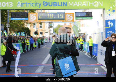 Dublino, Irlanda. 28 ott 2013. Runner irlandese Sean Hehir ha vinto gli uomini di gara del 2013 Airtricity maratona di Dublino in 2:18:19. Egli è il primo corridore irlandese a vincere la maratona in vent'anni. Il vincitore di uomini della gara, Sean Hehir, huggs direttore di gara Jim Aughney nella zona di finitura. Credito: Michael Debets/Alamy Live News Foto Stock