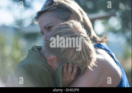 Una madre dà il suo pianto figlio un abbraccio Foto Stock