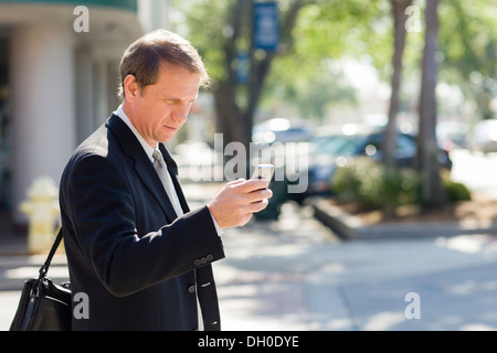 Imprenditore caucasico tramite telefono cellulare Foto Stock