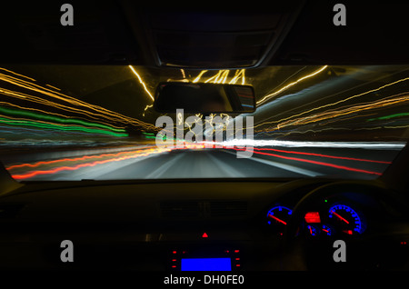 Vista attraverso il parabrezza di una vettura in movimento con motion blur e diverse sezioni sull'autostrada con opere stradali Automobili Autocarri Foto Stock