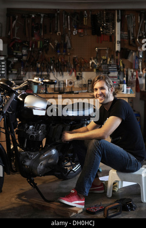 Caucasica lavoro meccanico sul motociclo Foto Stock