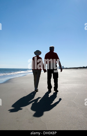 Coppia di anziani caucasici (età 60-70) Tenendo le mani e camminando a Myrtle Beach SC Foto Stock