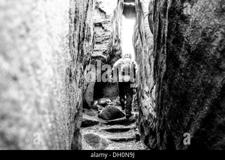 Un uomo è in esecuzione attraverso la sabbia rocce. REPUBBLICA CECA Foto Stock