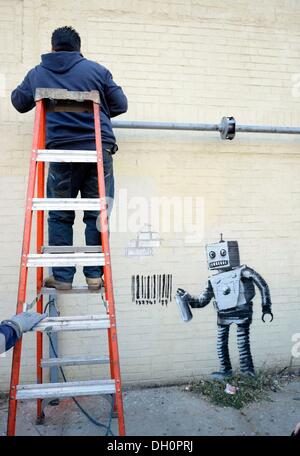 New York, NY, STATI UNITI D'AMERICA. 28 ott 2013. Banksy sulla posizione per Graffiti artist Banksy Robot di etichette con codice a barre e piccione in Coney Island, Stillwell e Nettuno Avenue, New York, NY Ottobre 28, 2013. Credito: Derek Storm/Everett raccolta/Alamy Live News Foto Stock
