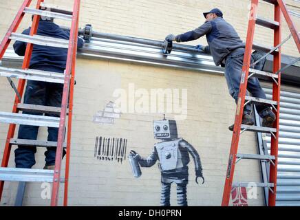 New York, NY, STATI UNITI D'AMERICA. 28 ott 2013. Banksy sulla posizione per Graffiti artist Banksy Robot di etichette con codice a barre e piccione in Coney Island, Stillwell e Nettuno Avenue, New York, NY Ottobre 28, 2013. Credito: Derek Storm/Everett raccolta/Alamy Live News Foto Stock