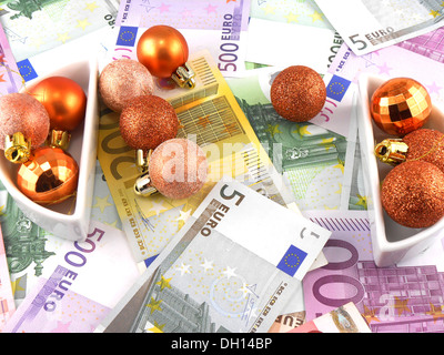 Le banconote in euro con le palle di Natale su di esso Foto Stock