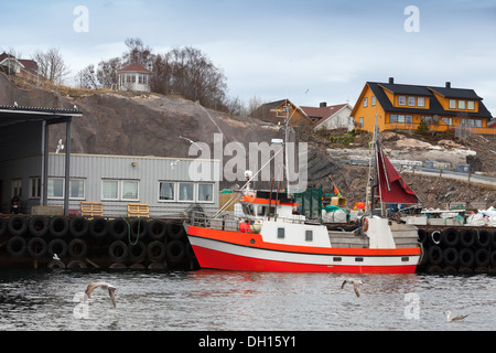 Piccolo rosso e bianco barca da pesca sta ormeggiata in Norvegia Foto Stock
