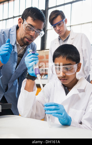 L insegnante e gli studenti a lavorare nel laboratorio di scienze Foto Stock